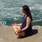 Genevieve meditates rock ocean